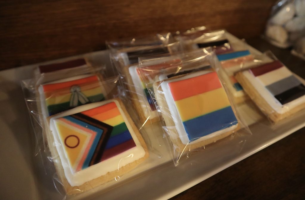 Various pride flag cookies sit on a shelf.