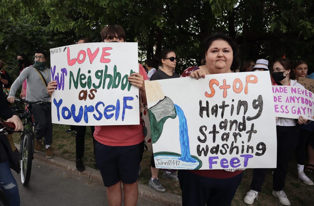 Two people hood up songs with bible verses expressing love and not hatred. 