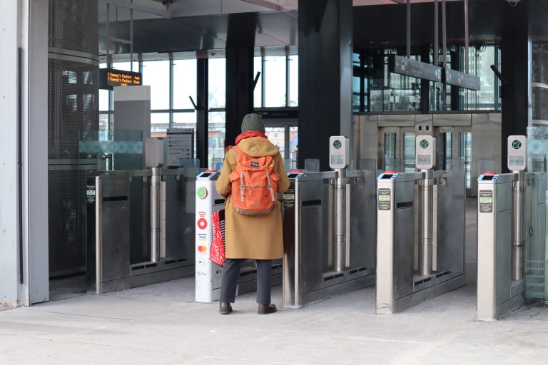 A woman goes through the fare gates at Tunney’s Pasture station.