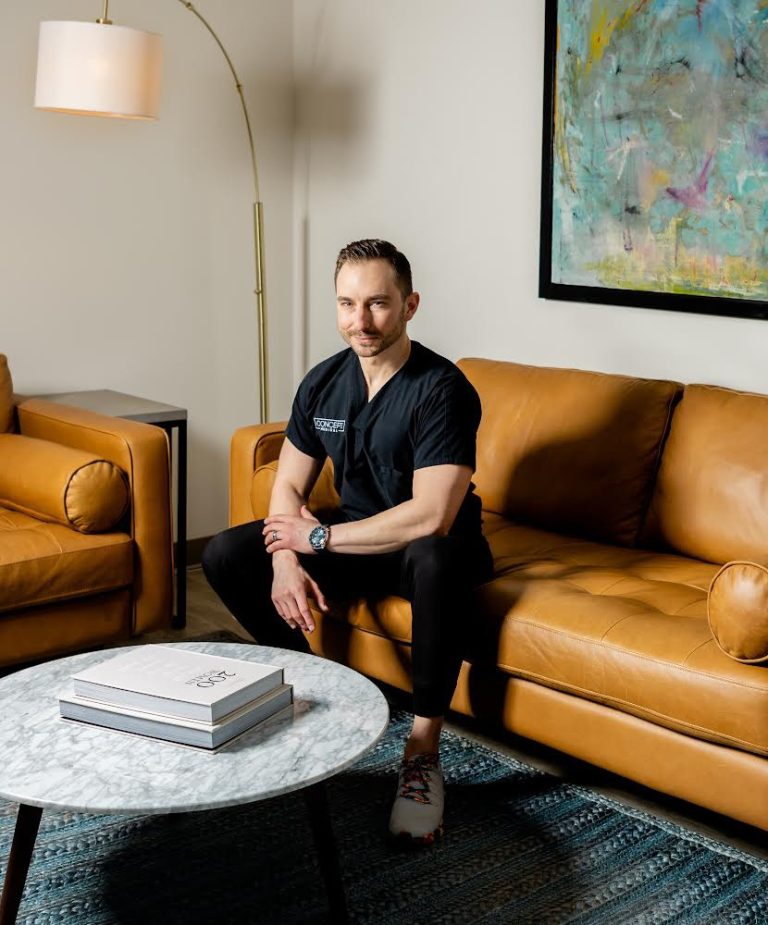 A photo of Dr. Sam Hetz sitting on a copper coloured couch