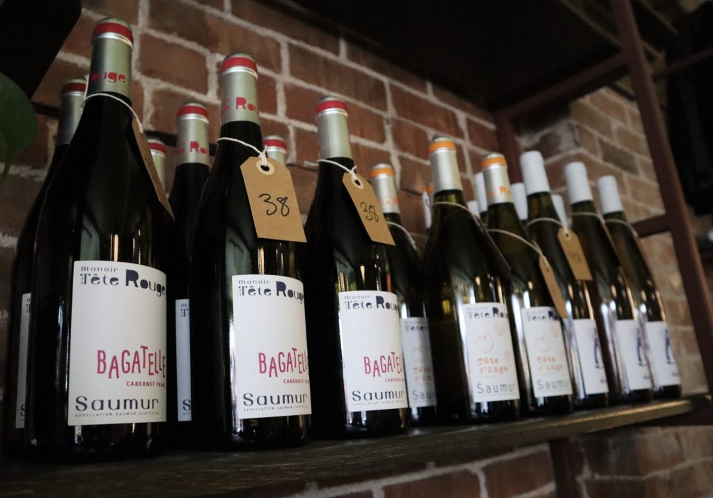 Bottles of wine sit on a shelf. 