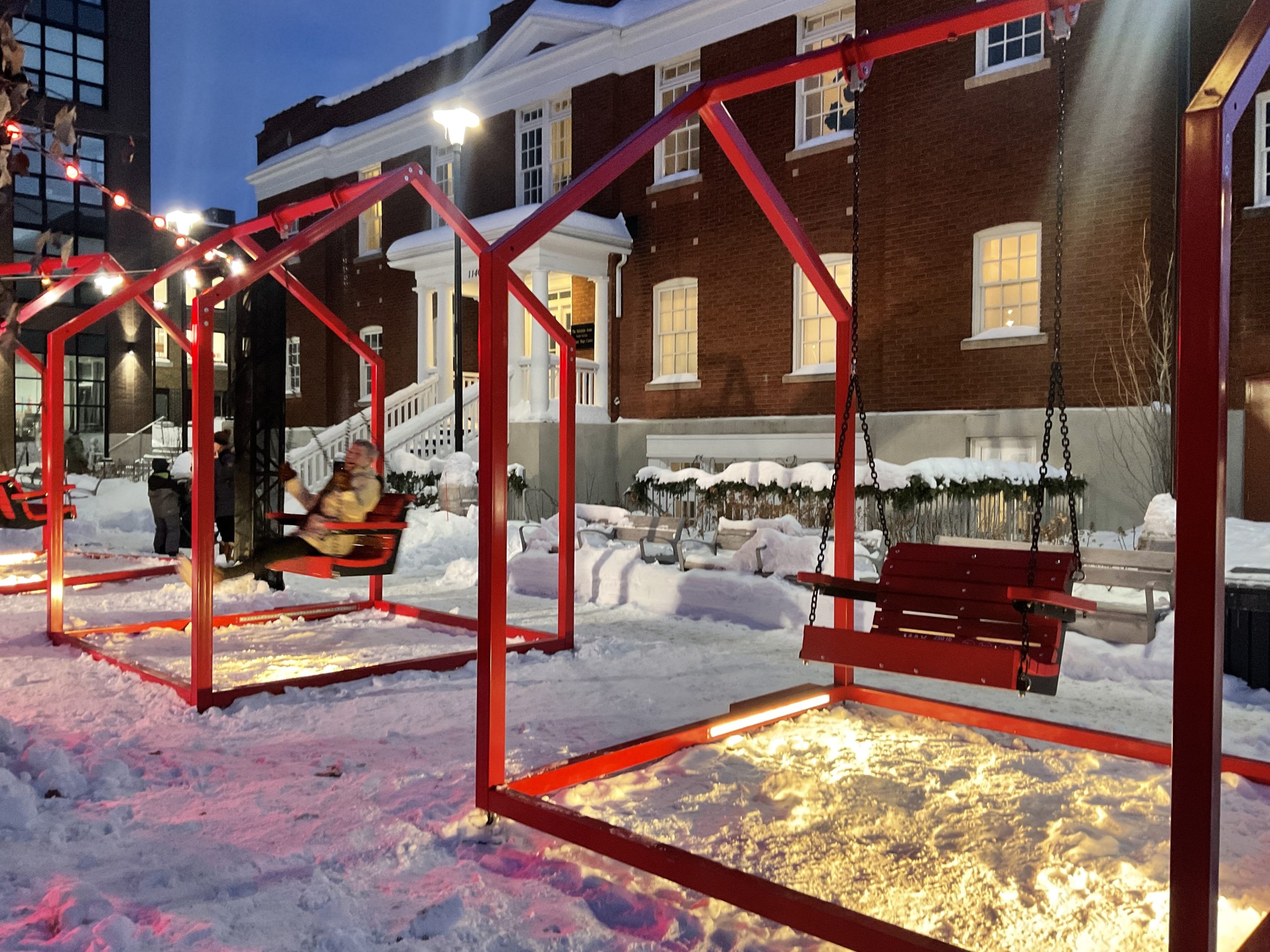 Two red swings are on display outside of the Salvation Army Building on Wellington Street West