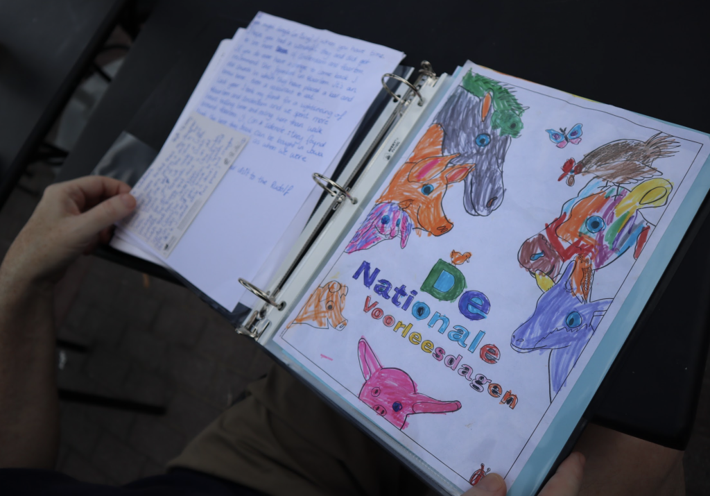 A close up photograph of inside the binder. A letter is on one side and a drawing on the other.