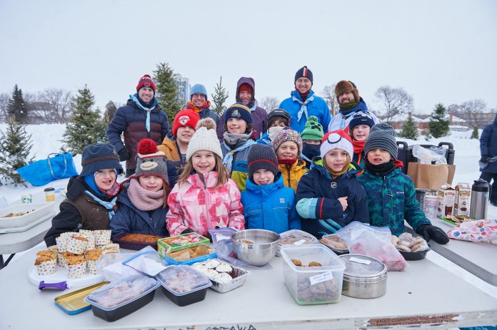 A group of children pose for a photograph while wearing winter clothing