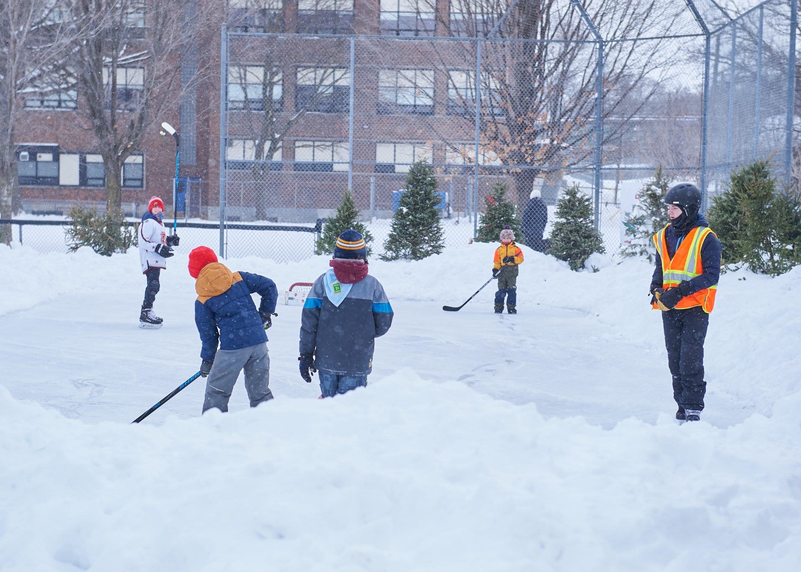 Kids play hockey on a small rink.