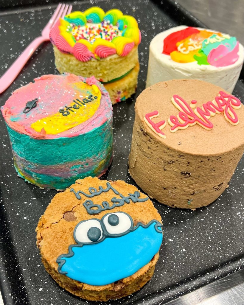 A few different cakes sit on a counter. 