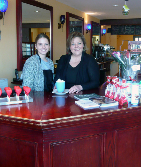 Retail associate Chelsea Chapman (L) and Cococo store owner Céline Levo with a cup of the house-made hot chocolate. Photo by Heather Heagney