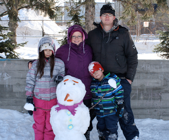 Melissa and Gerard Stiles-O’Connell pose with Maliah, 9, Corey, 5, and the family’s snowman creation. Photo by Anita Grace.