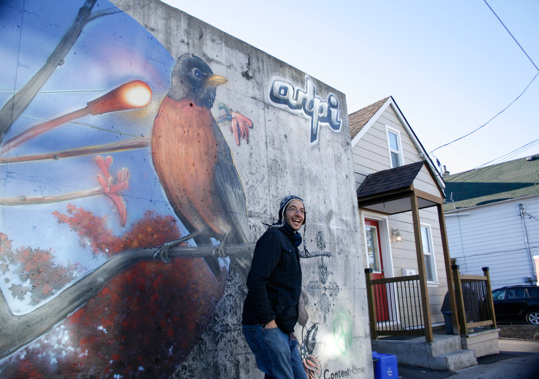 Local street artist Arpi in front of his new mural at the corner of Garland and Lowrey Street. Photo by Jacob Hoytema