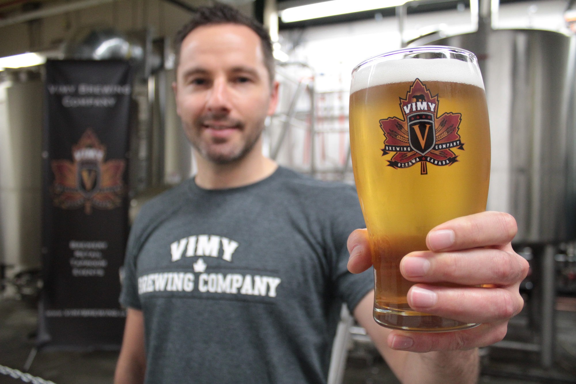 Vimy Brewing Company co-owner and -founder Kevin Sirko holds up a glass of the Vimy Cream Ale in their new facility at 145 Loretta Ave. N.