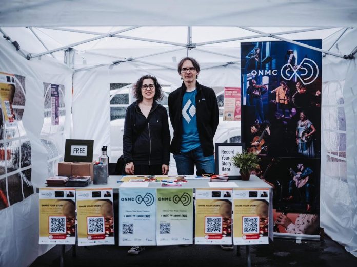 Frank and Lisa pose for a photo at a booth.