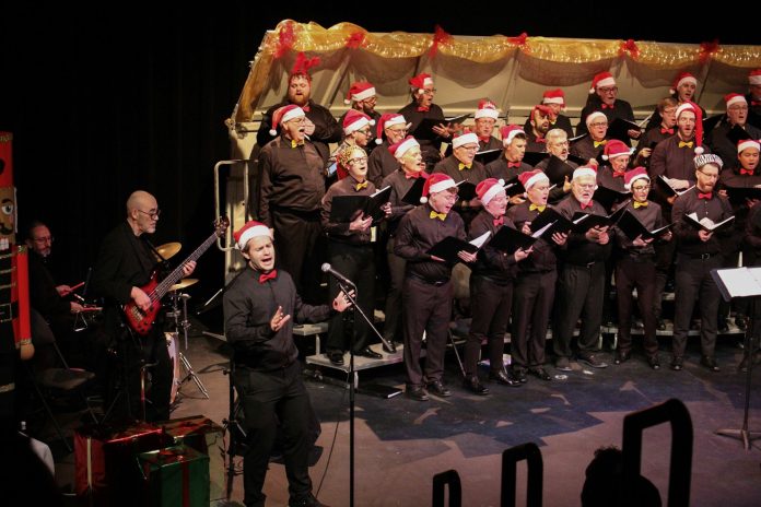 A large group of men sing in a choir.