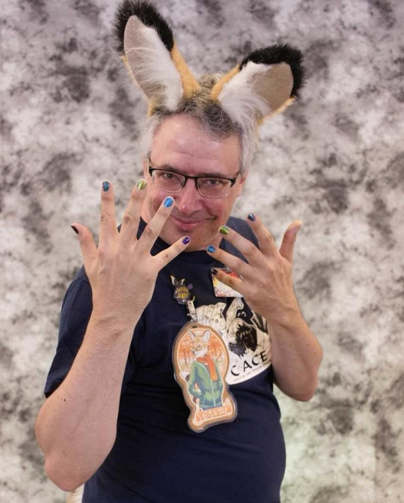 A man with painted nails wears fox ears.